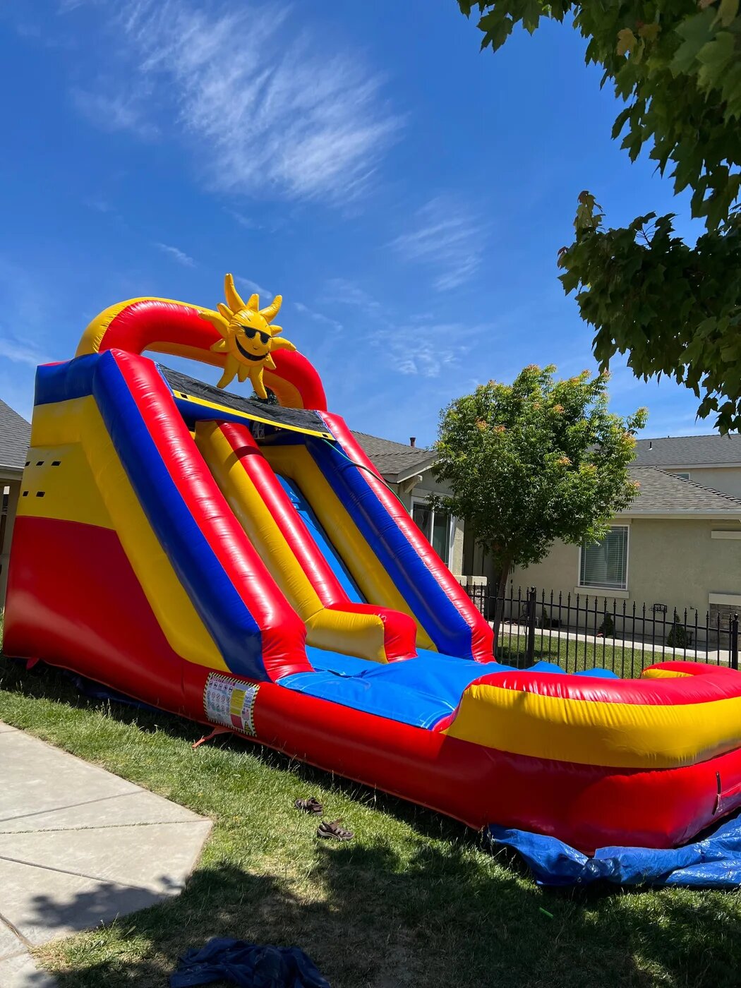 Inflatable water slide set up for a backyard birthday party