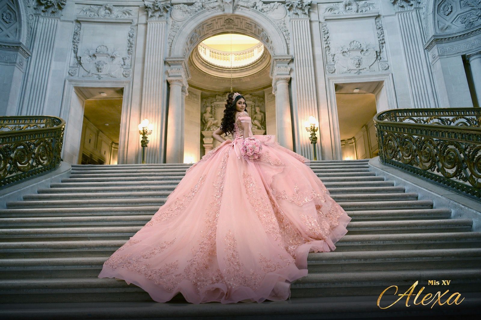 Quinceañera in pink ball gown on grand staircase
