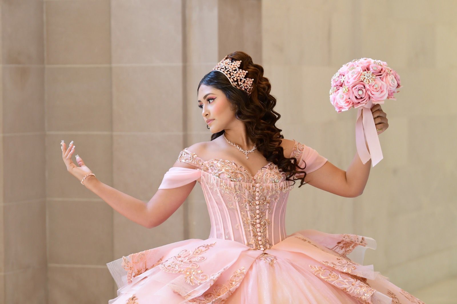 Quinceañera in pink gown dancing with bouquet