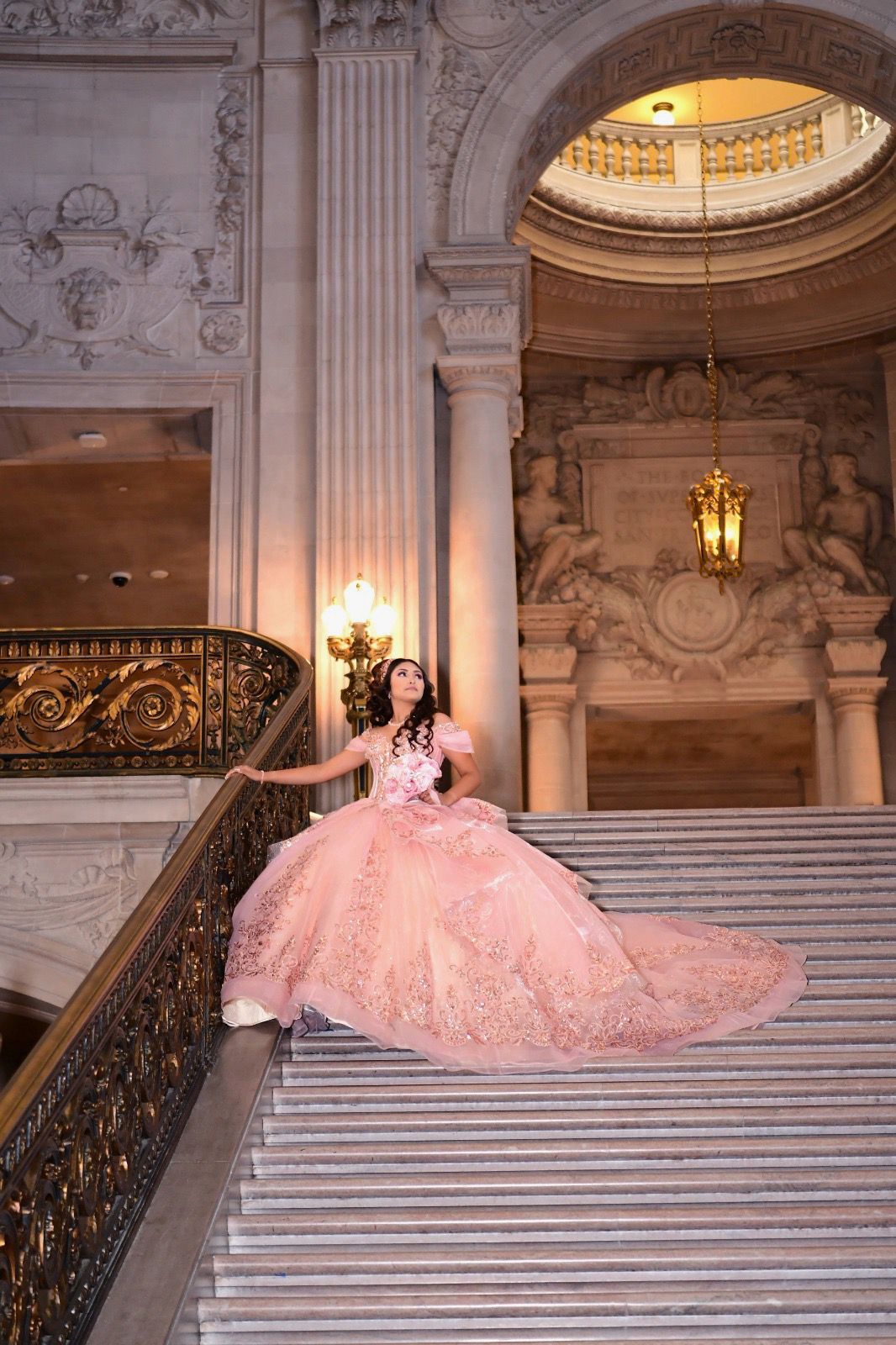 Quinceañera in pink ball gown on grand SF City Hall staircase